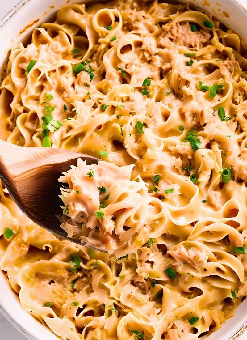 A fork lifting a bite of tuna noodle casserole – strands of saucy noodles stretching slightly, highlighting the smooth, creamy consistency and tender tuna. (2)