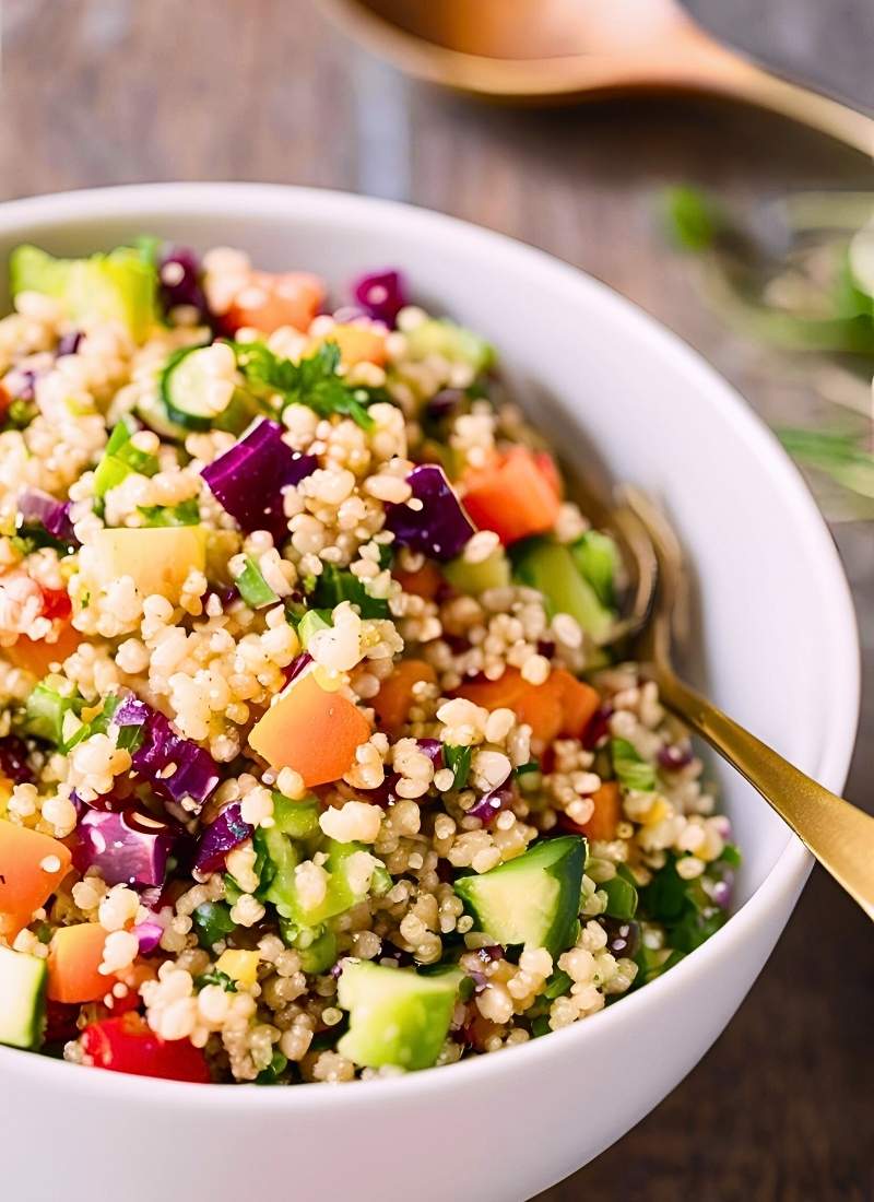 In a large bowl, combine the quinoa, roasted tomatoes, arugula, cucumbers, basil and mint, feta, olives, onion, and pine nuts. toss to combine, then drizzle with half the dressing and toss again.